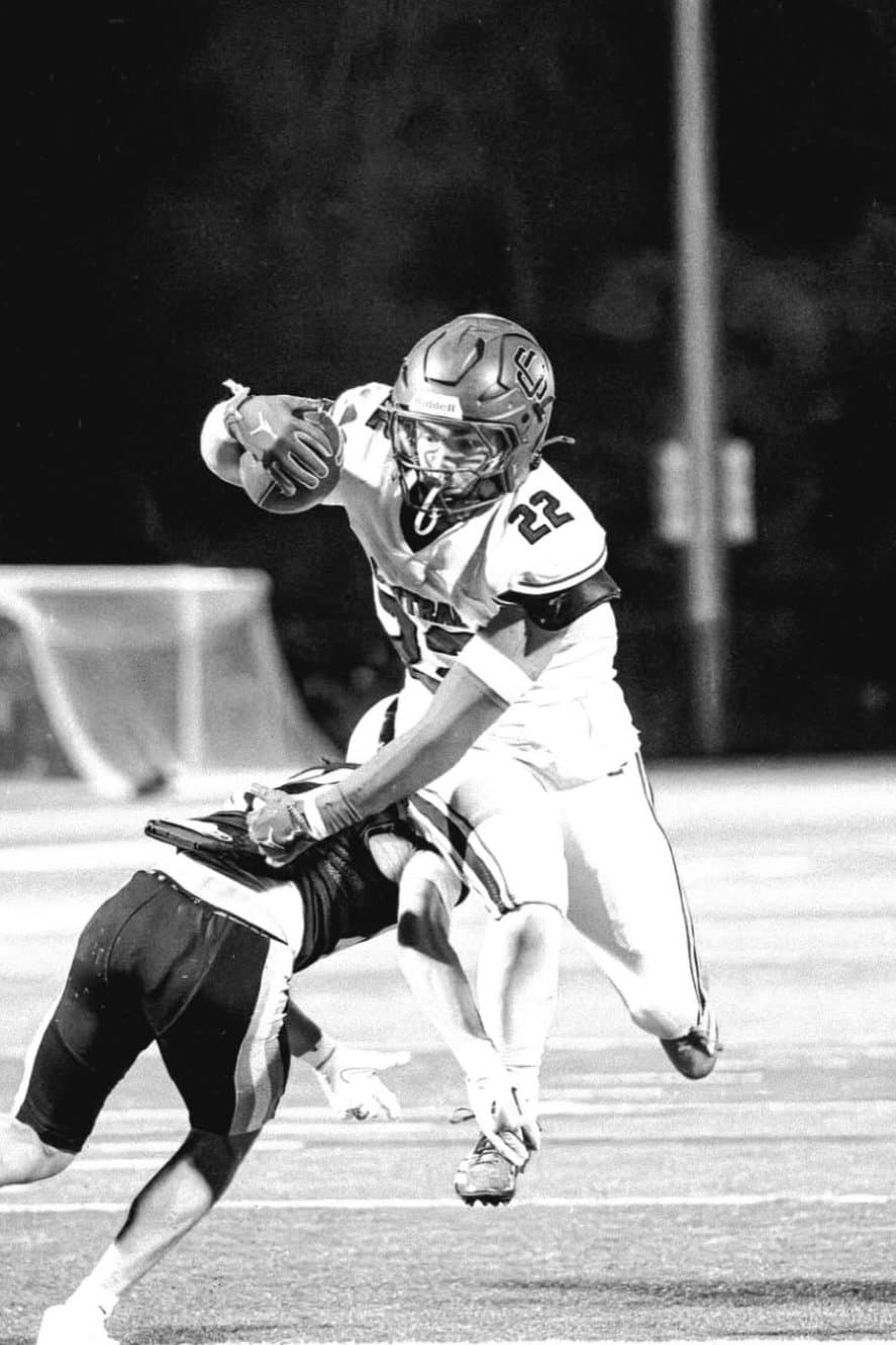 Athlete breaking a tackle under the Friday night lights